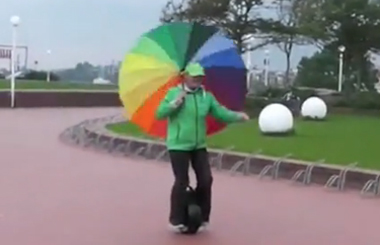 扛着大伞骑Airwheel腾博会官网以诚信为本平衡车，这位阿姨也是够拼的，哈哈！